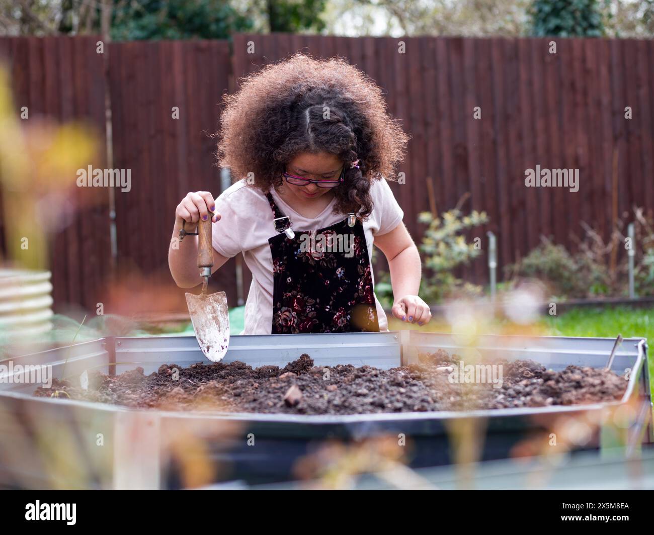 Girl doing gardening work in backyard Stock Photo