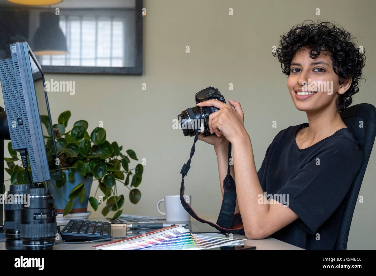 Portrait of female photographer working in creative office Stock Photo