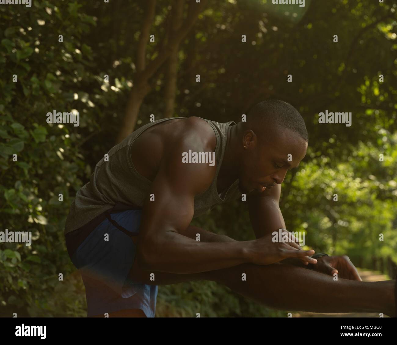 Athletic man stretching in park Stock Photo