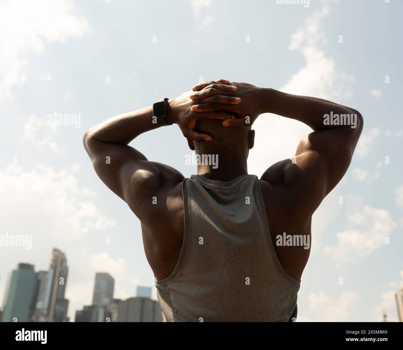 USA, New York City, Rear view of athletic man facing city skyline Stock Photo