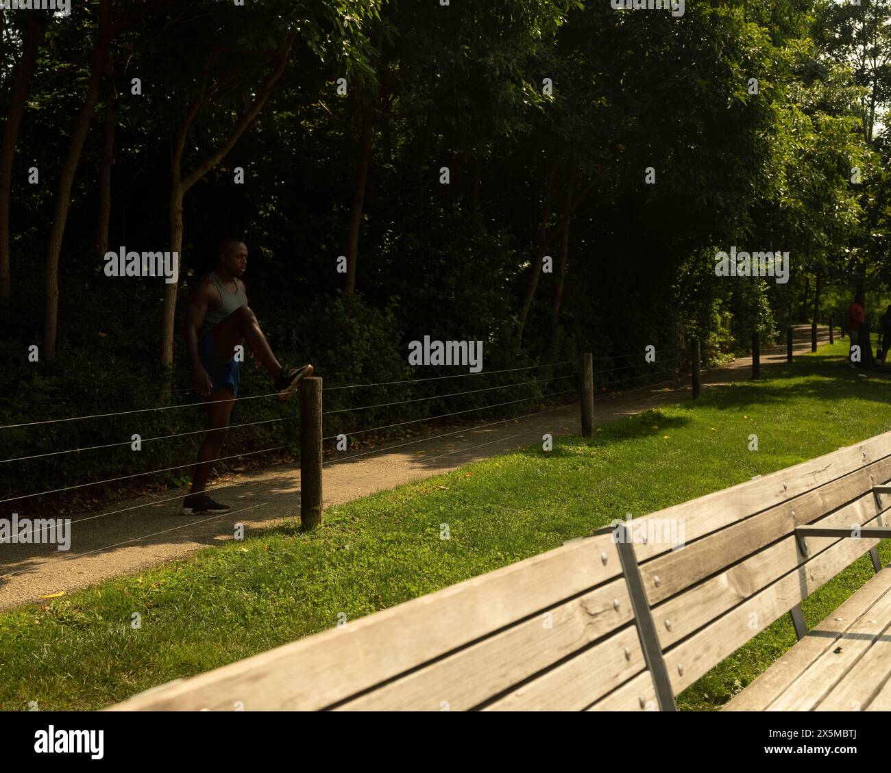 Athletic man stretching in park Stock Photo