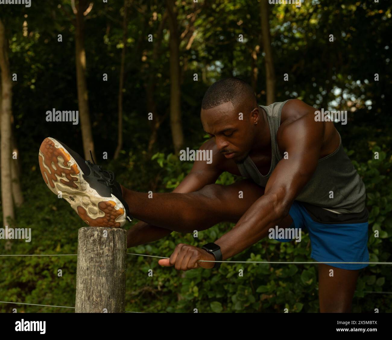 Athletic man stretching in park Stock Photo