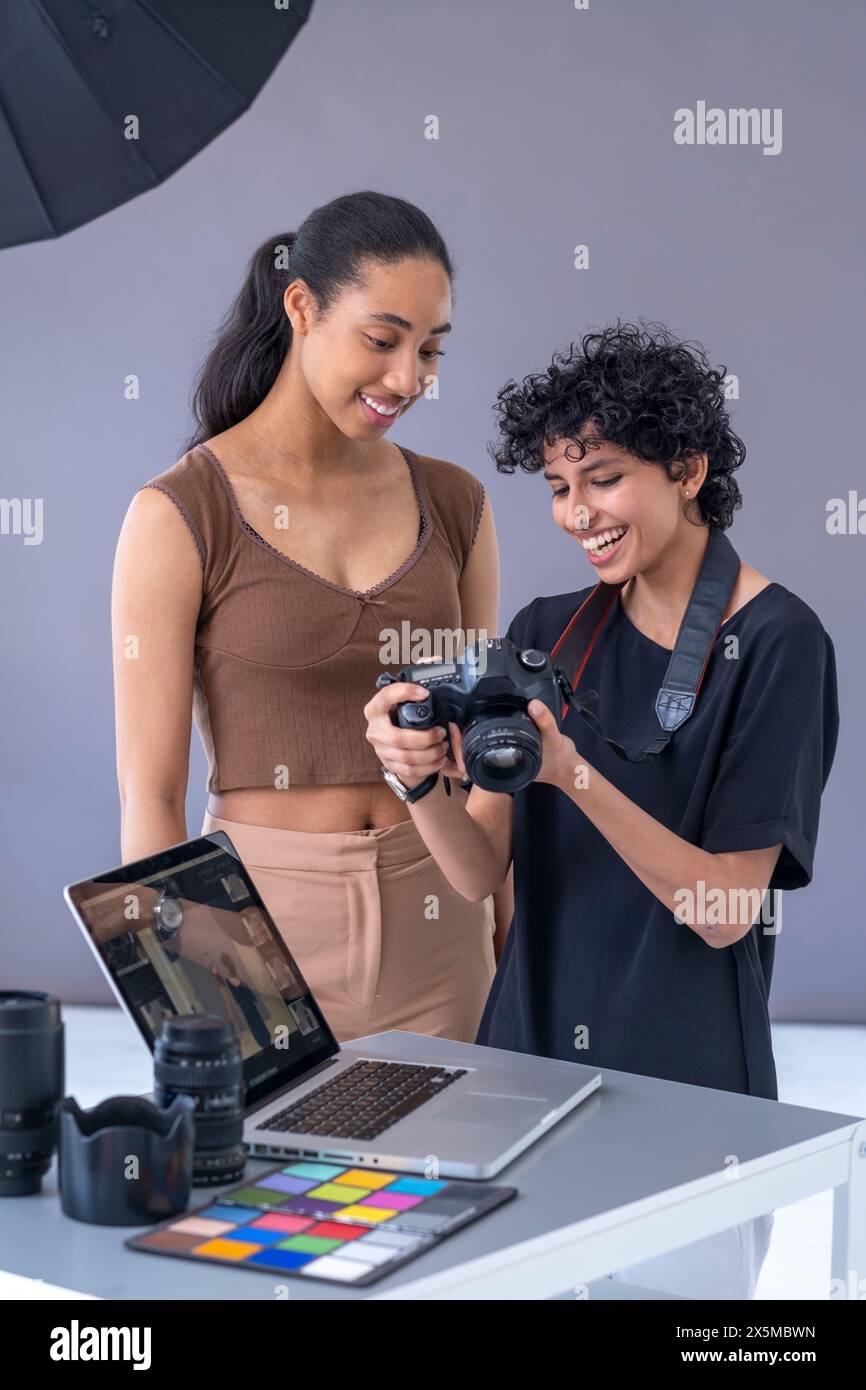 Photographer Using Model Model and photographer looking at camera during photo shoot Stock Photo ...