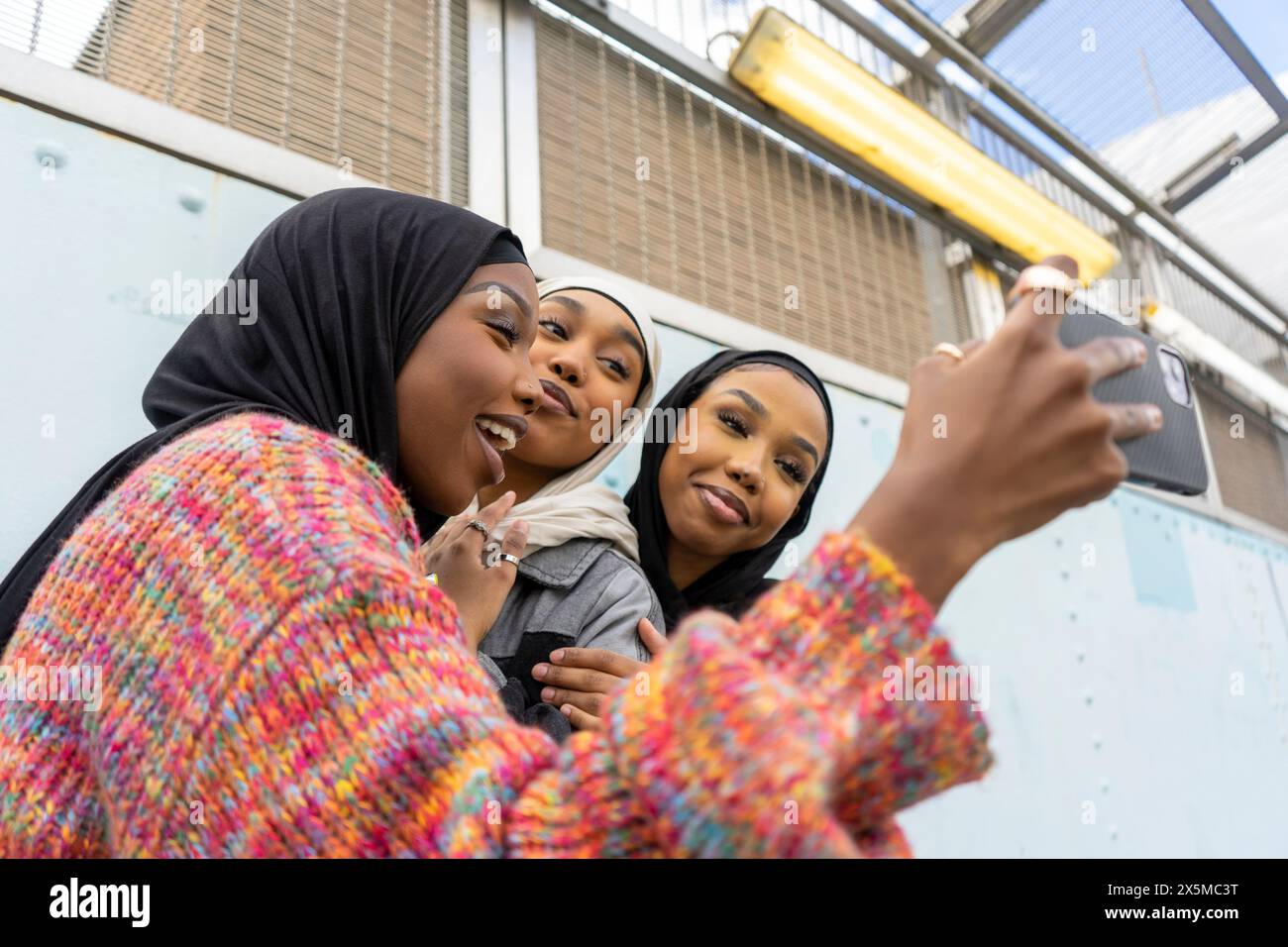 Smiling young women wearing hijabs taking selfie Stock Photo