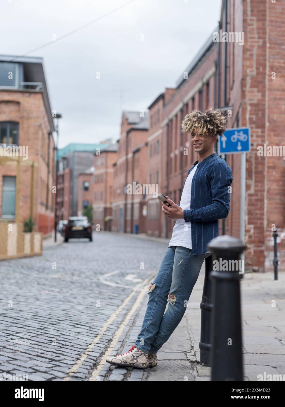 Smiling man using smart phone in city Stock Photo