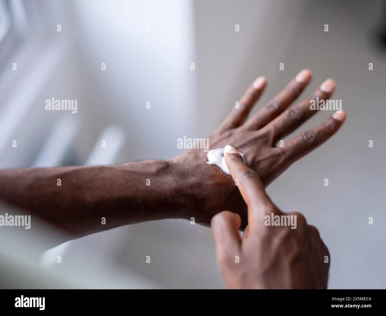 Close-up of person applying moisturizer on hand Stock Photo - Alamy
