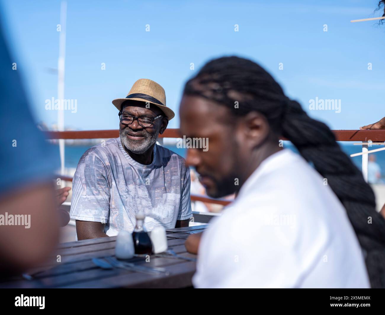 Family sitting in outdoor restaurant Stock Photo