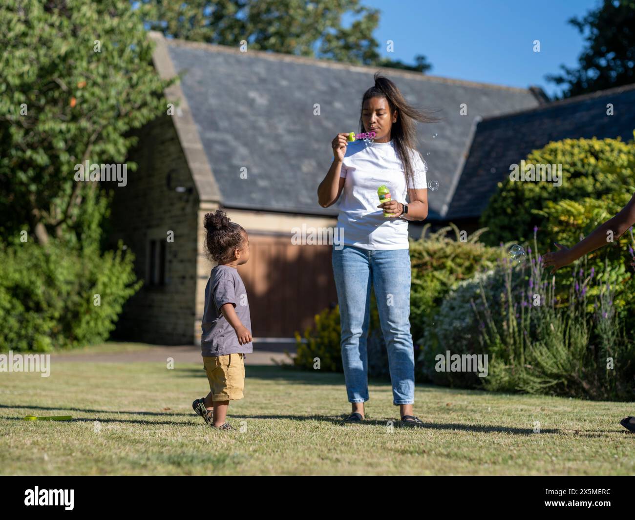 Mother with son (2-3) blowing soap bubbles Stock Photo