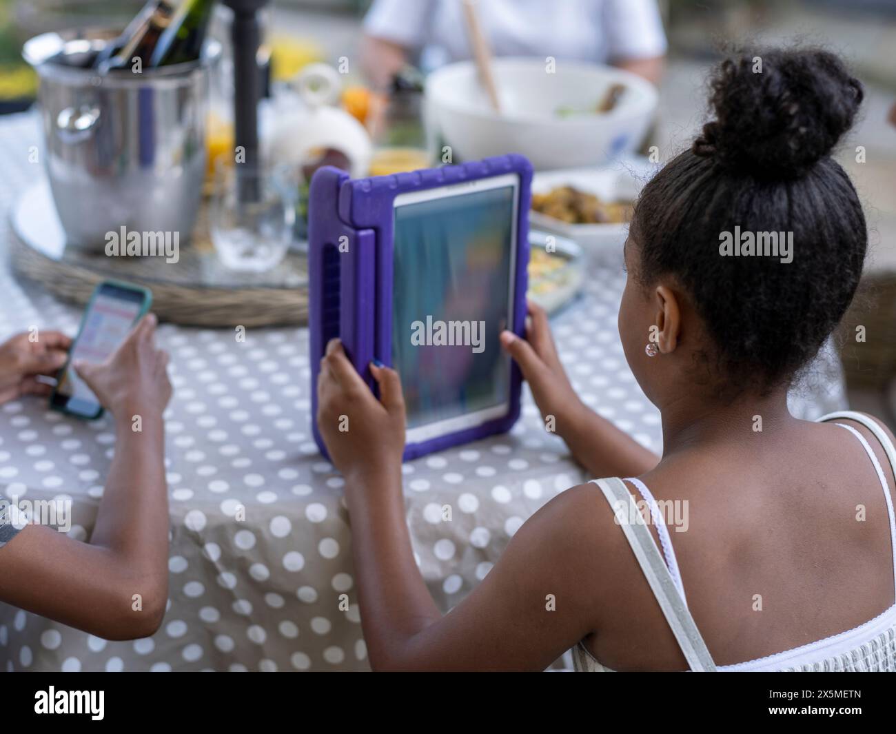 Siblings (8-9, 10-11) using digital tablet and smart phone Stock Photo