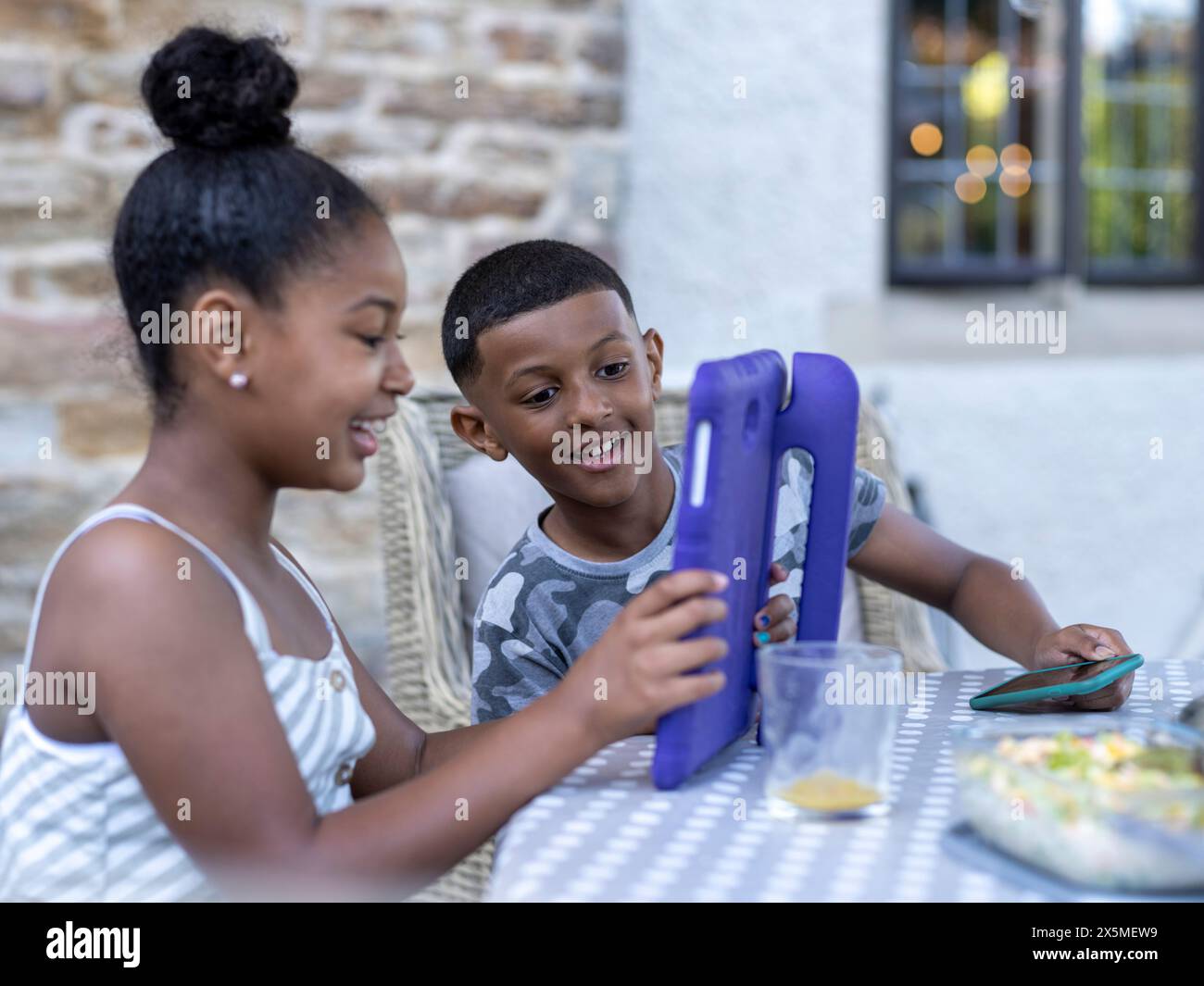 Siblings (8-9, 10-11) using digital tablet Stock Photo