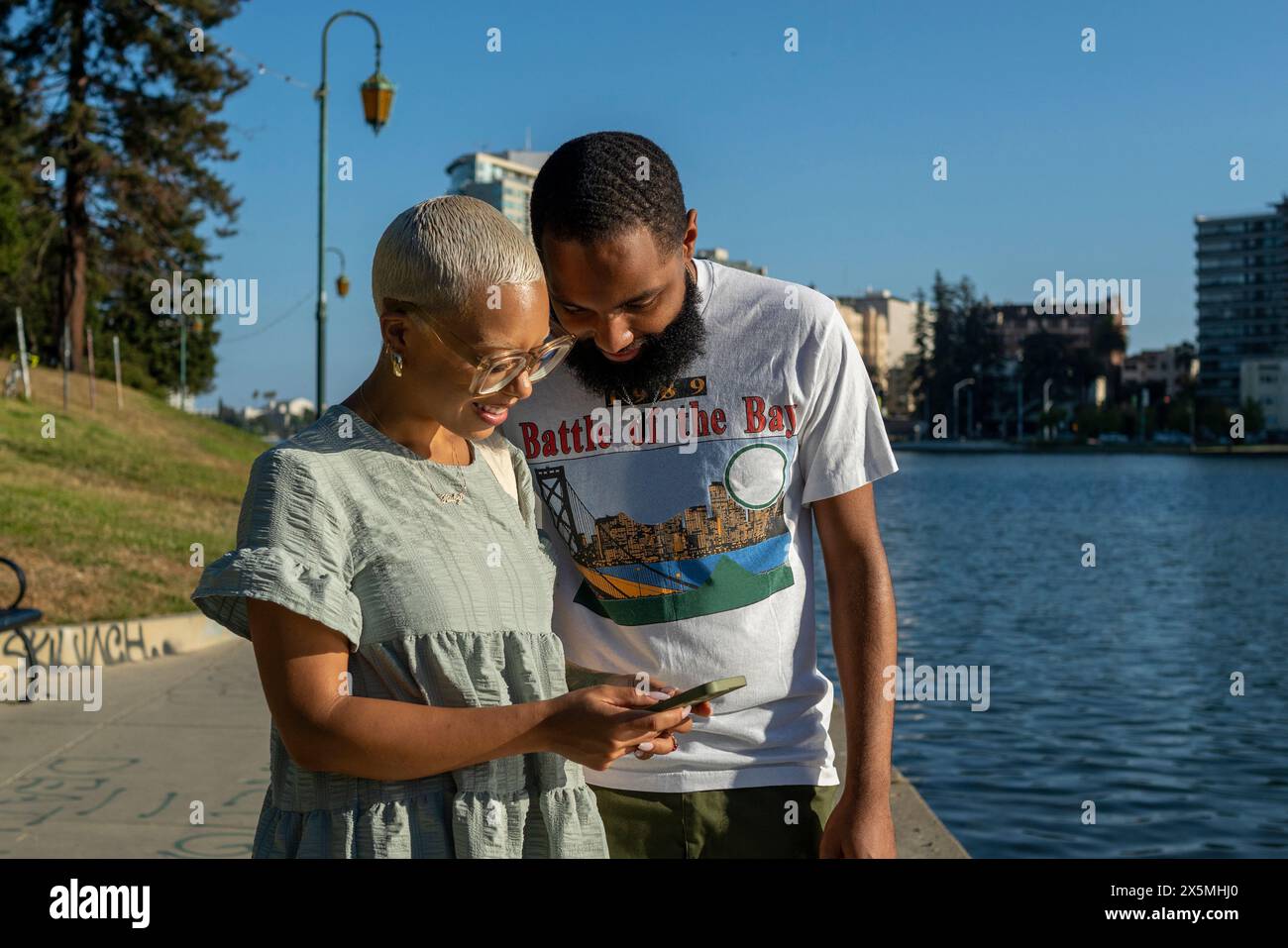 Couple using smart phone in city Stock Photo