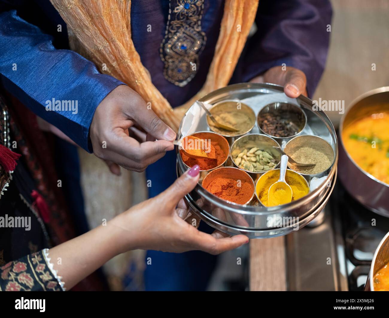 Mother and son using spices to cook Diwali food Stock Photo - Alamy