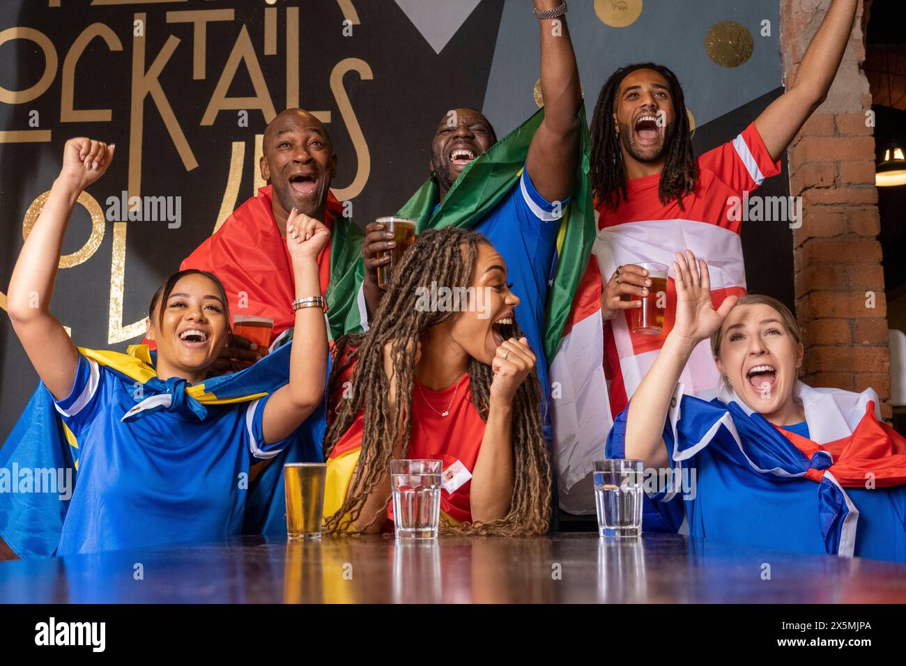 Friends dressed in national flags celebrating world cup competition ...