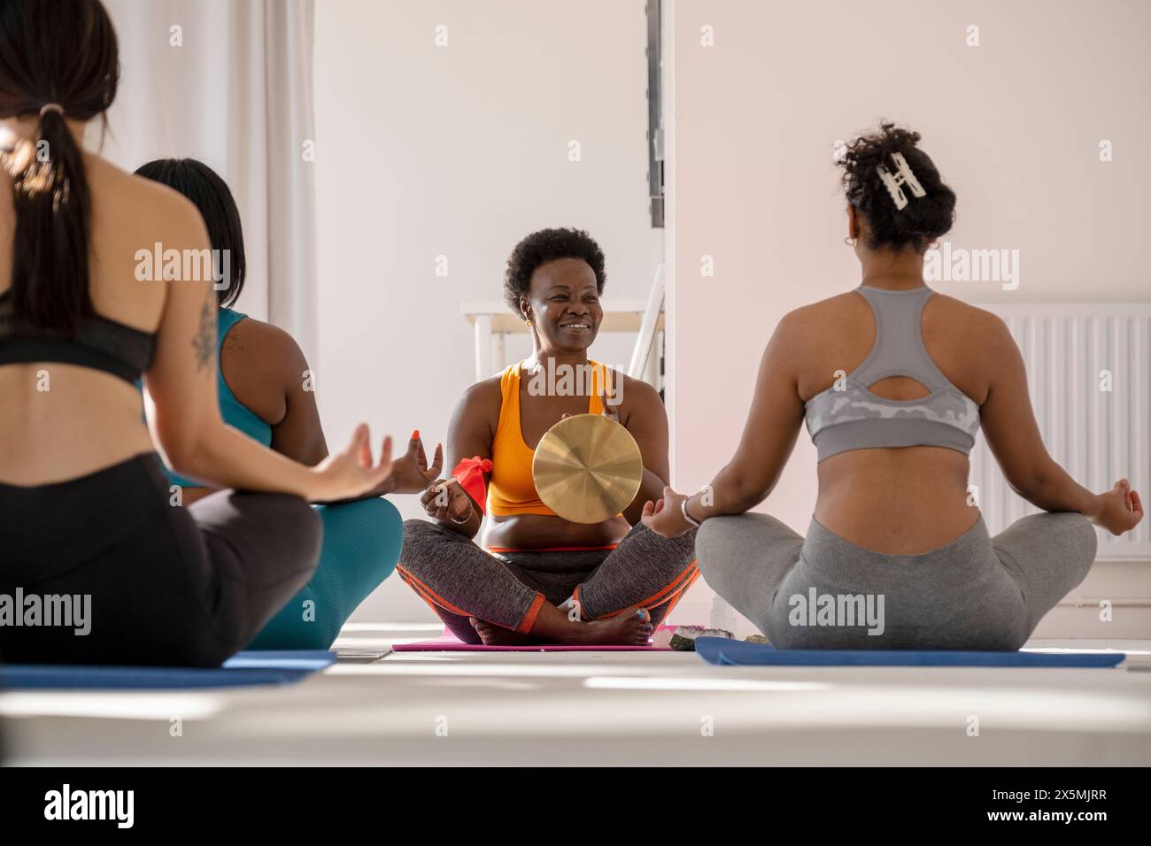 Women meditating in yoga studio Stock Photo - Alamy