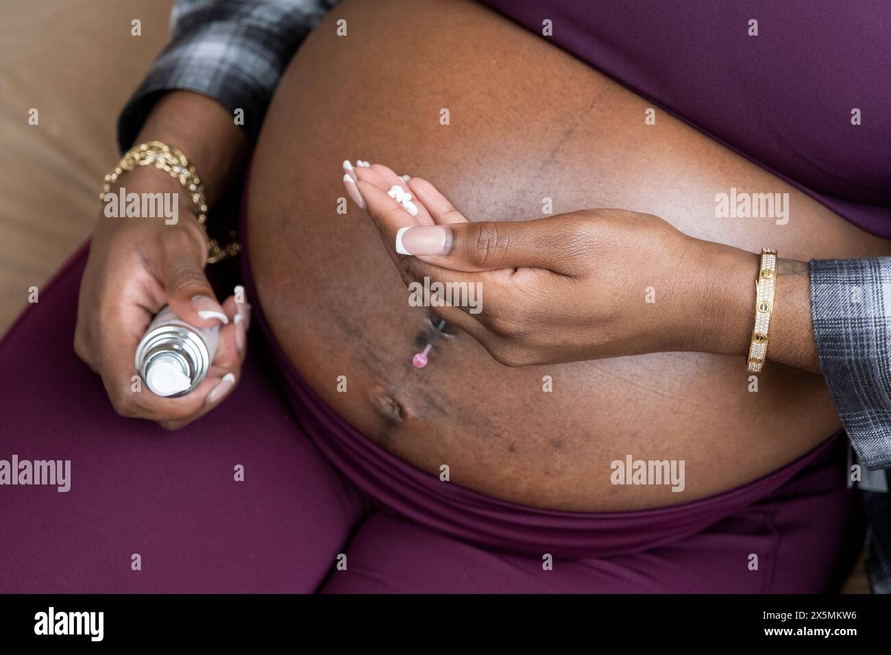 Pregnant woman?applying moisturizer on belly Stock Photo