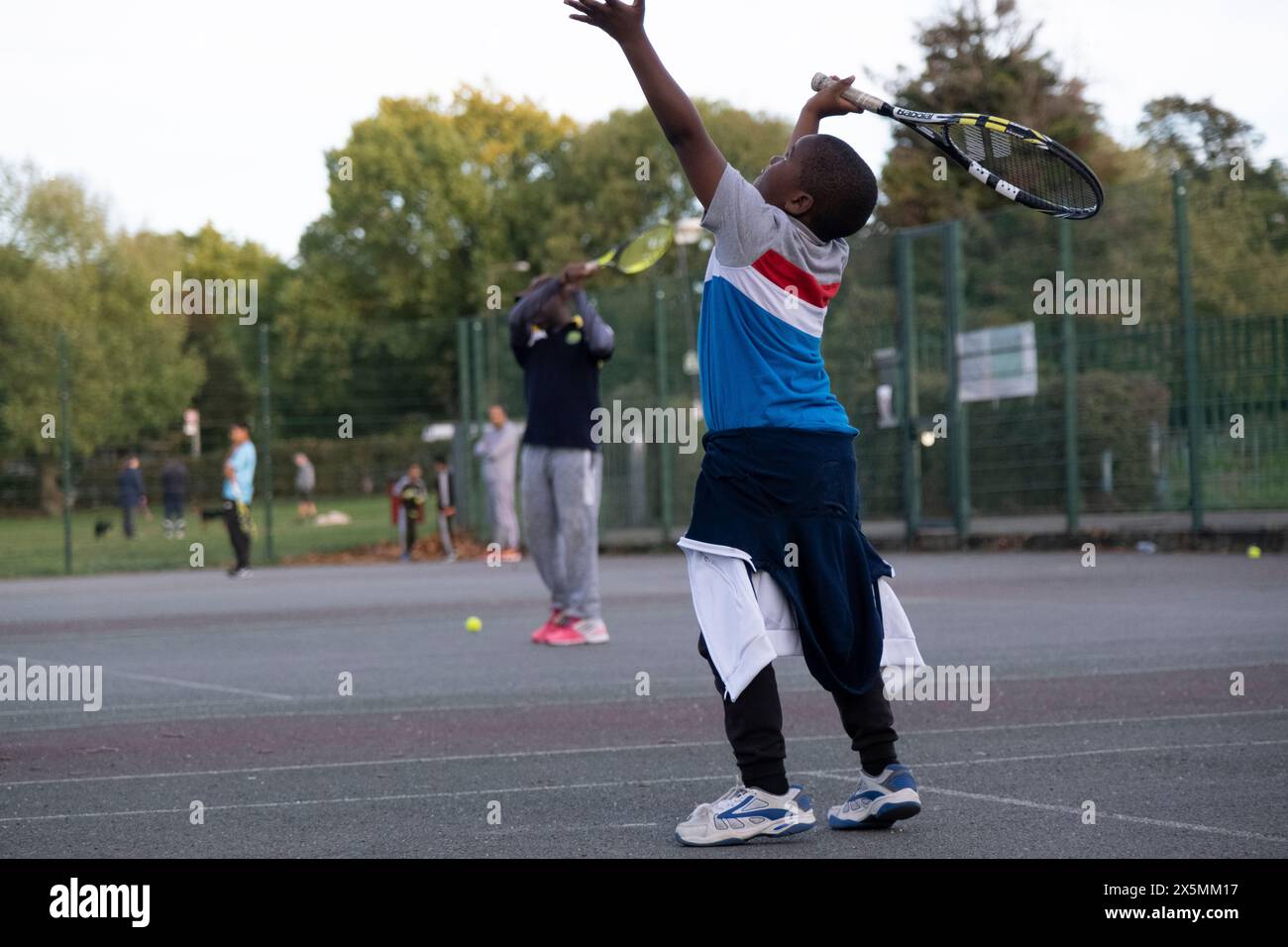 Children playing tennis on neighborhood court Stock Photo - Alamy
