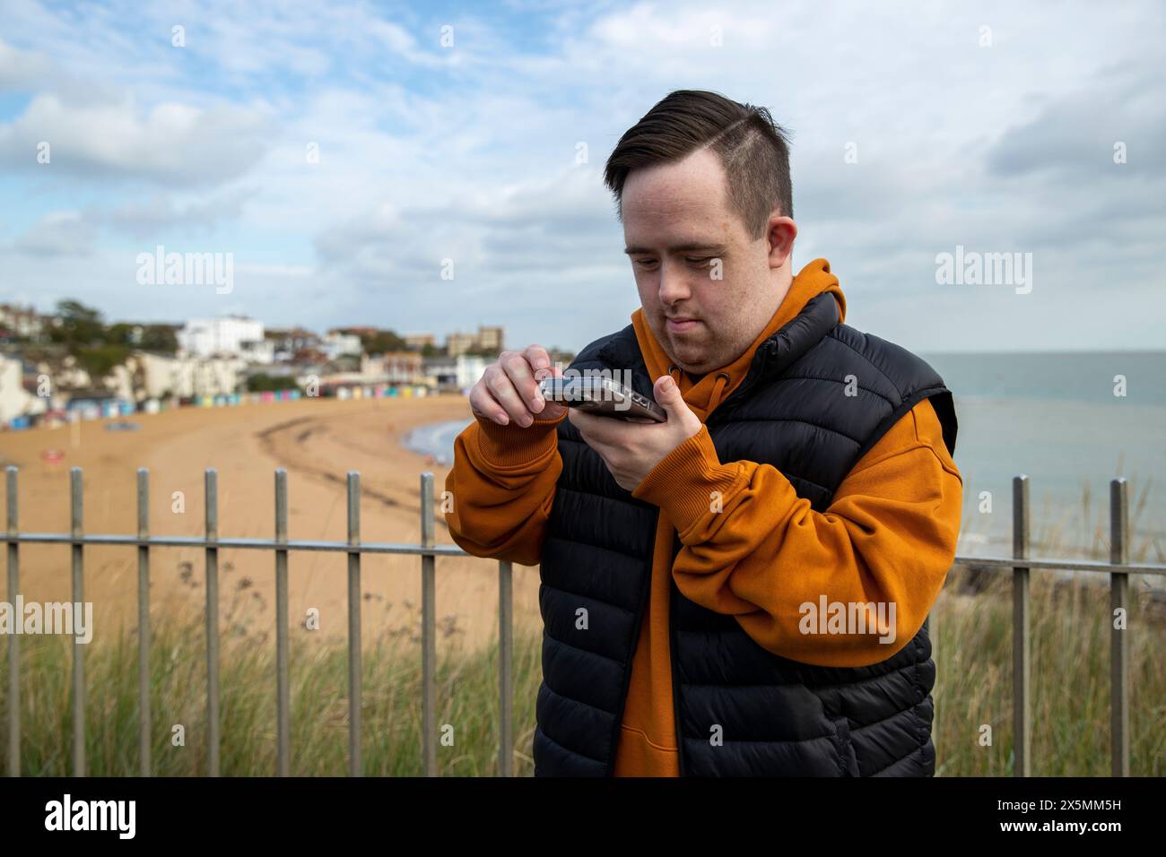 Man using smart phone by beach Stock Photo