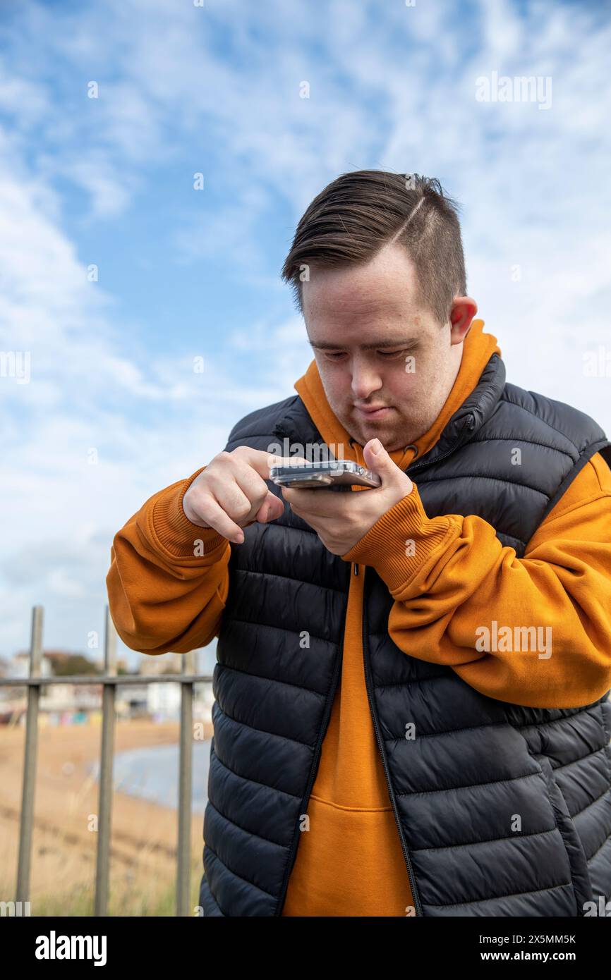 Man using smart phone by beach Stock Photo