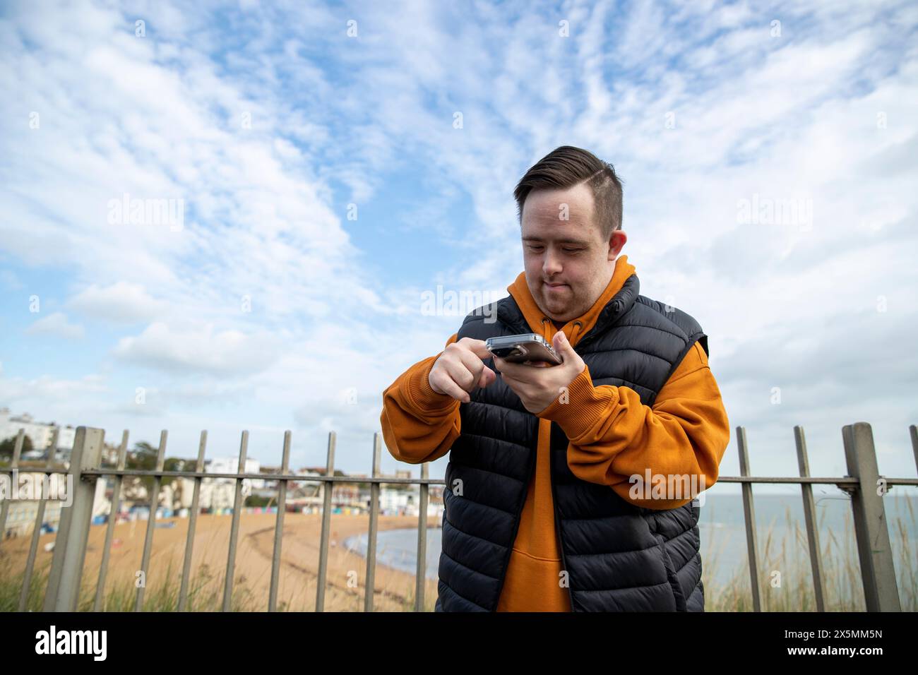 Man using smart phone by beach Stock Photo
