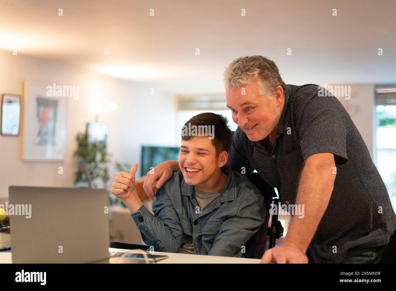 Father using laptop with son Stock Photo