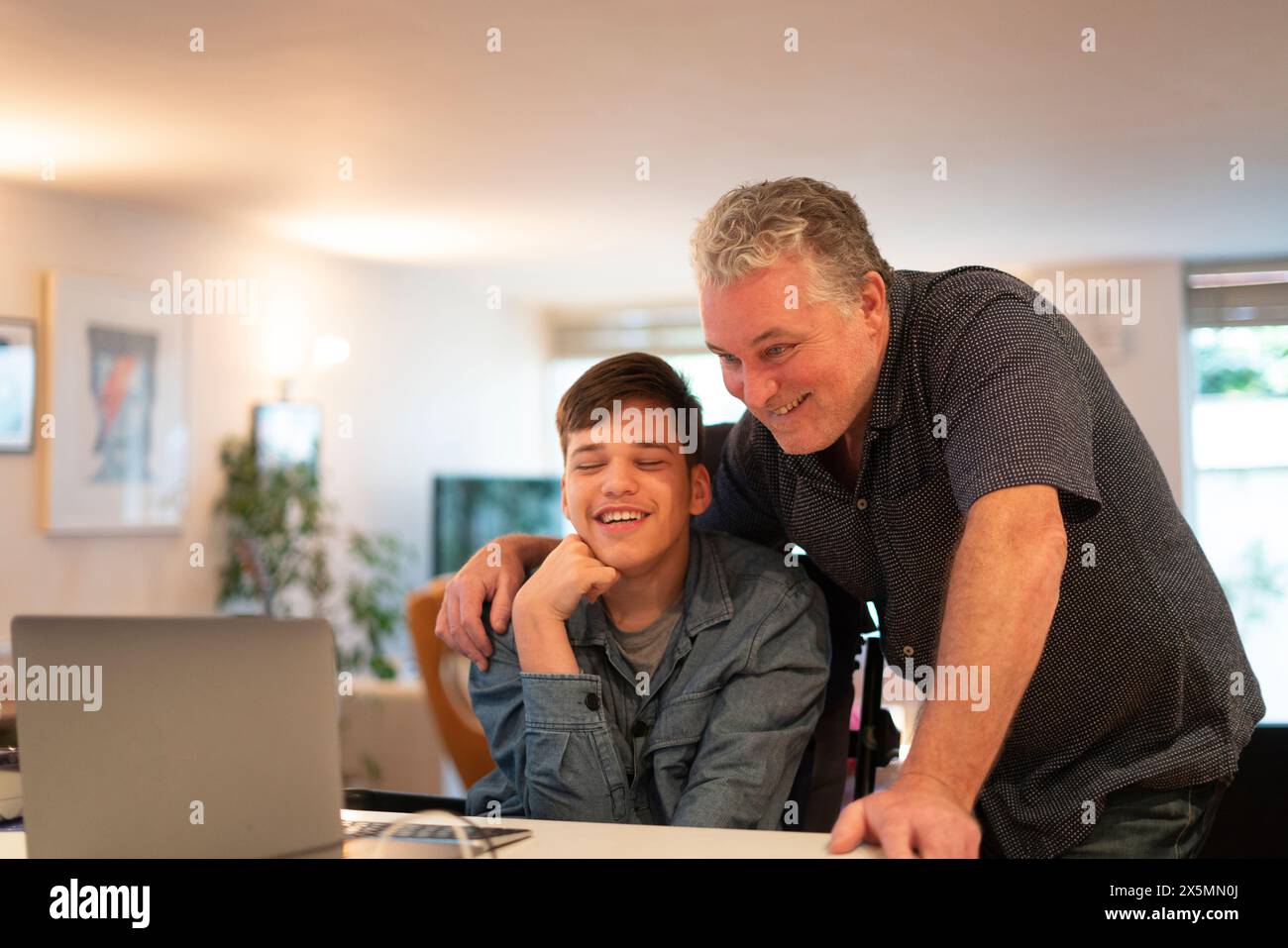 Father using laptop with son Stock Photo