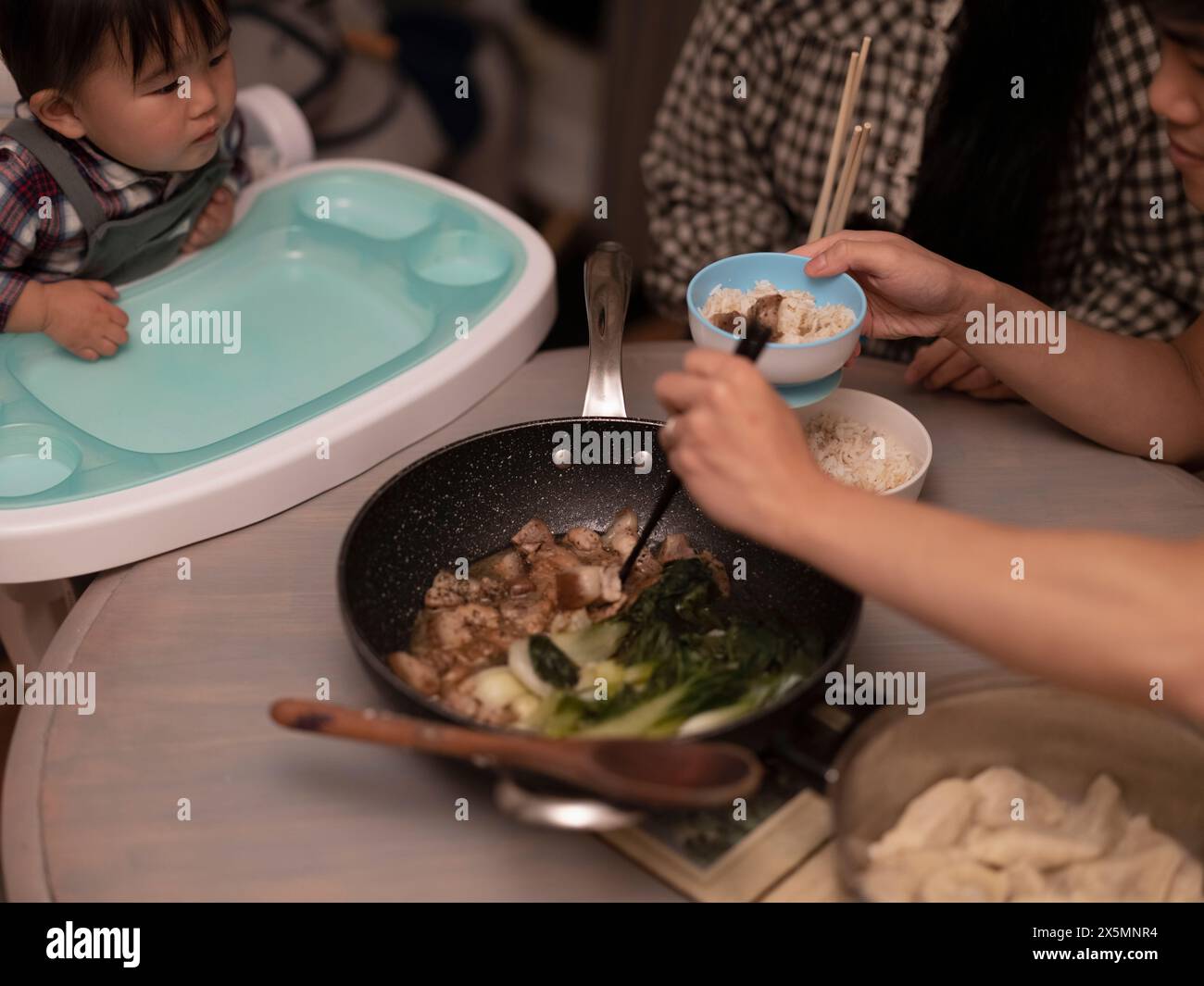 Parents with baby son eating dinner at home Stock Photo