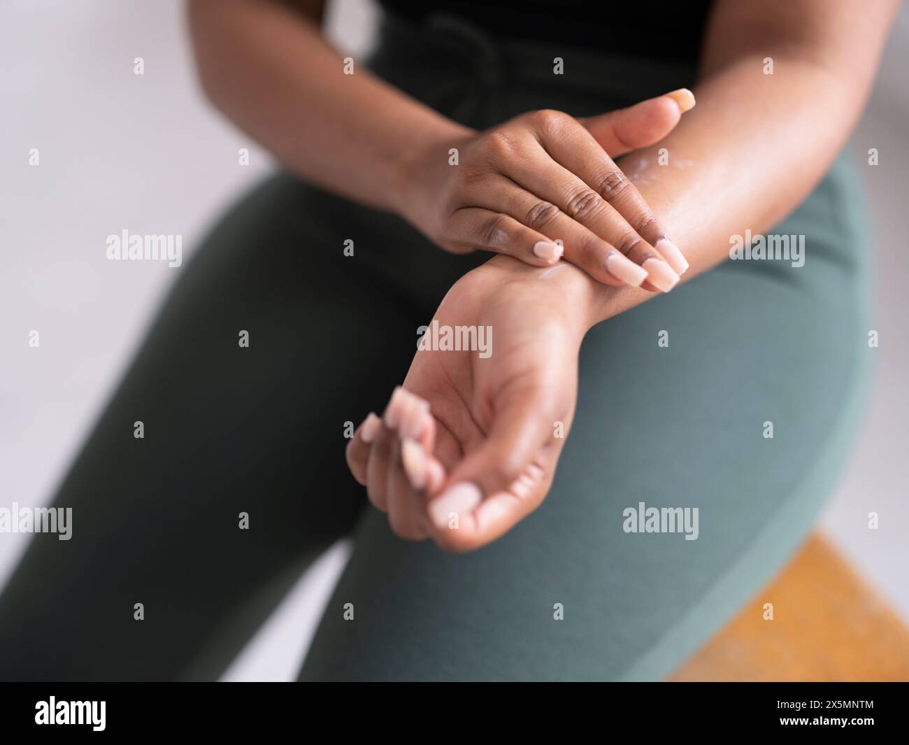 Close-up of woman applying body balm on arm Stock Photo - Alamy