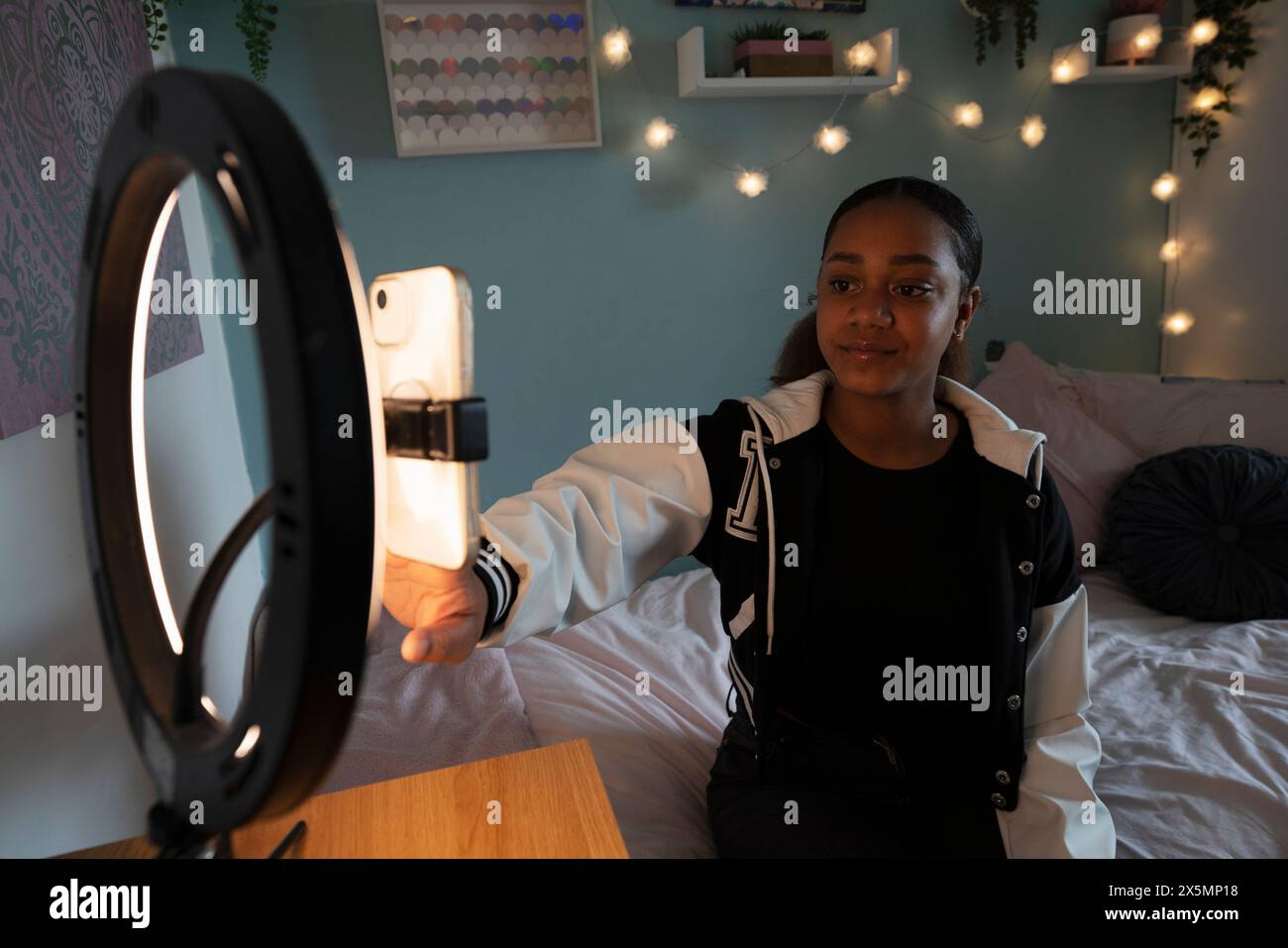 Girl setting up smart phone in ring light in bedroom Stock Photo - Alamy