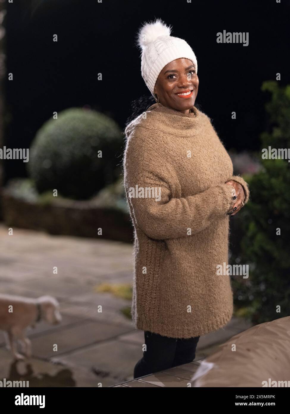 Portrait of smiling woman standing outdoors at night Stock Photo