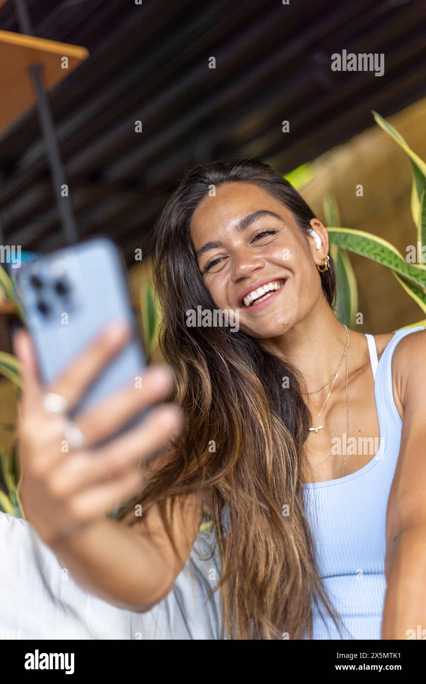 Woman sitting in hotel lounge and using mobile phone Stock Photo