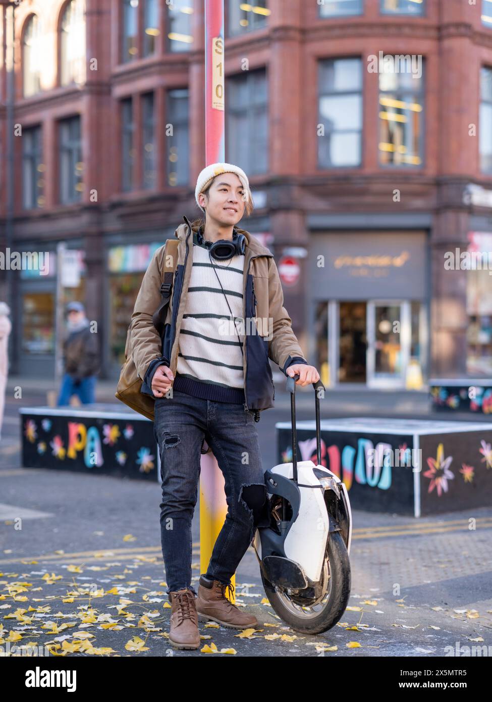 Portrait of man standing with electric unicycle in city Stock Photo