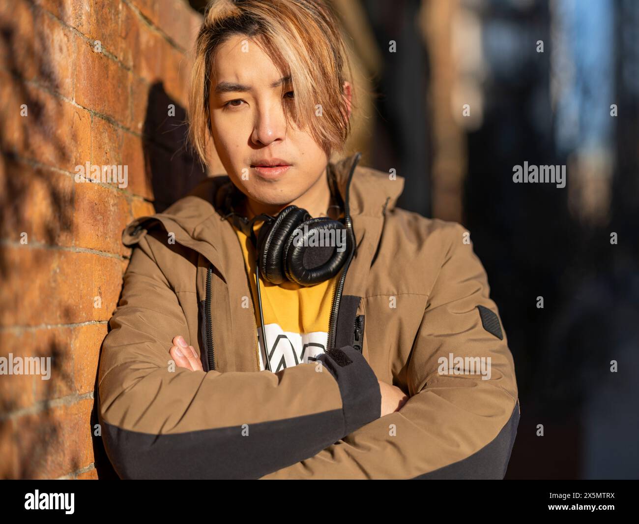 Portrait of serious man against brick wall Stock Photo