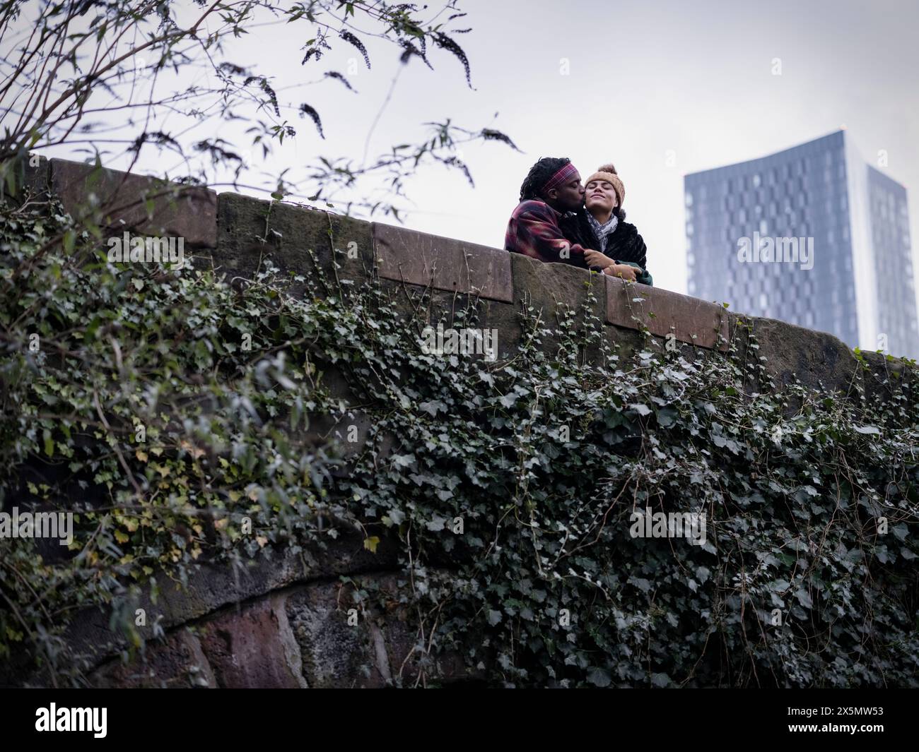 Couple hugging and kissing on bridge Stock Photo - Alamy