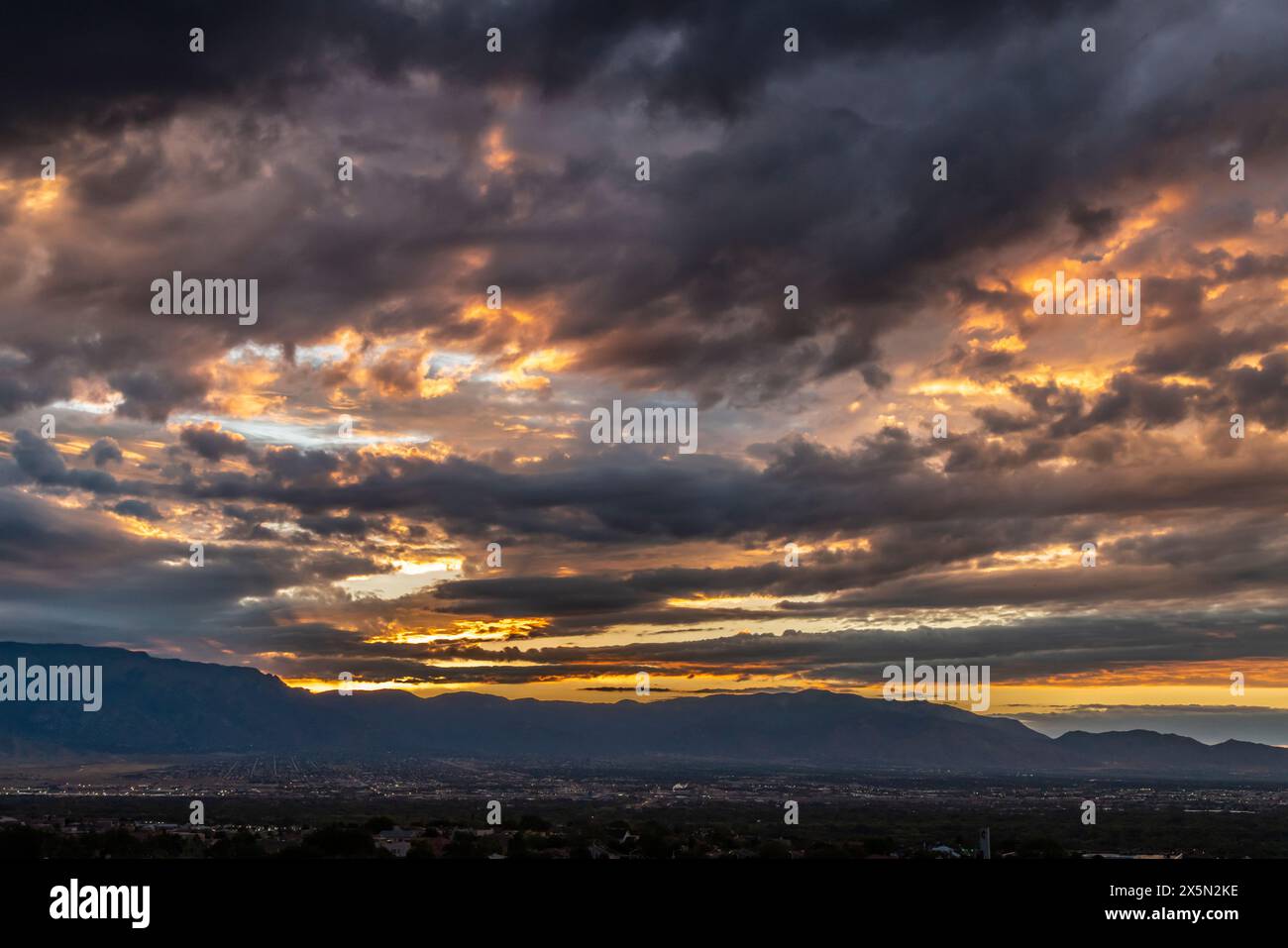 USA, New Mexico, Sandia Mountains. Cloudy sunrise over Albuquerque. Stock Photo