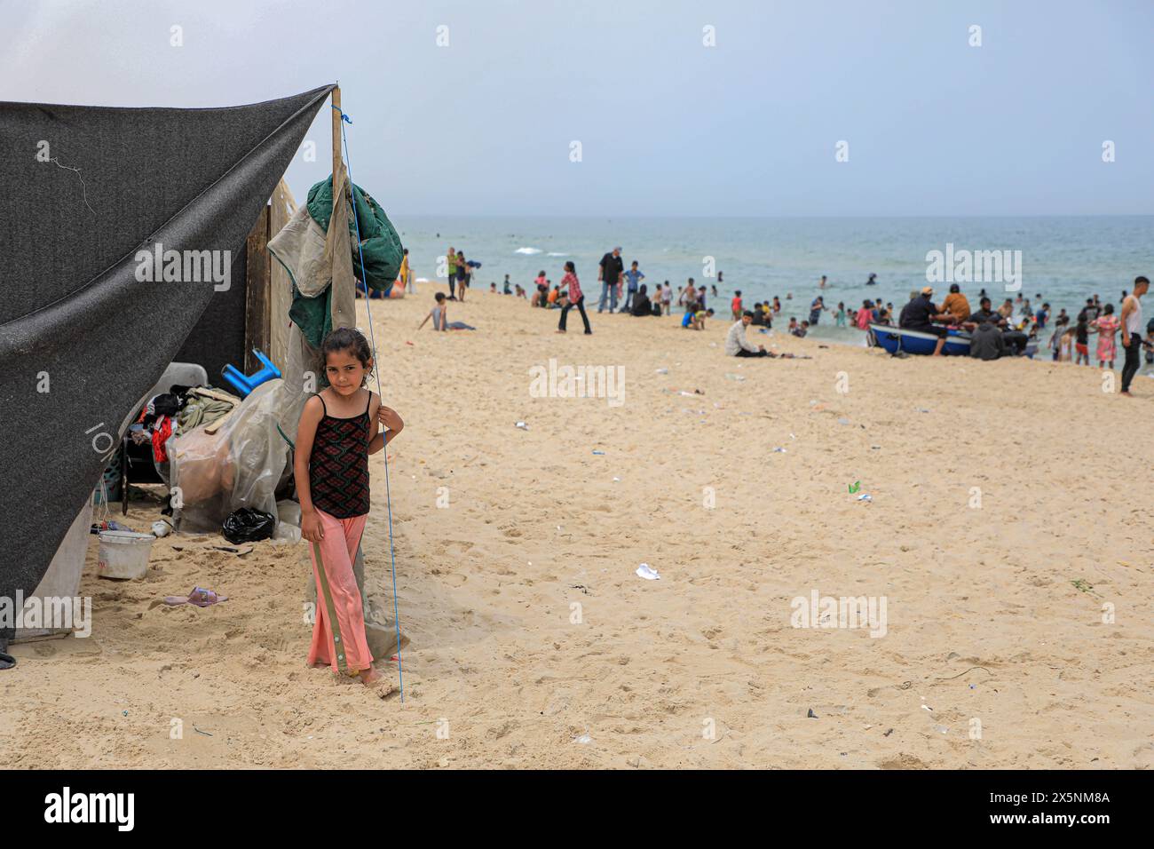 Gaza. 10th May, 2024. A Palestinian girl evacuated from Rafah stands by a tent at a beach in the southern Gaza Strip city of Khan Younis, on May 10, 2024. Around 110,000 people have fled Rafah in search of safety as Israeli bombardment intensifies in the city, the United Nations Relief and Works Agency for Palestine Refugees in the Near East (UNRWA) said on social media on Friday. Credit: Rizek Abdeljawad/Xinhua/Alamy Live News Stock Photo