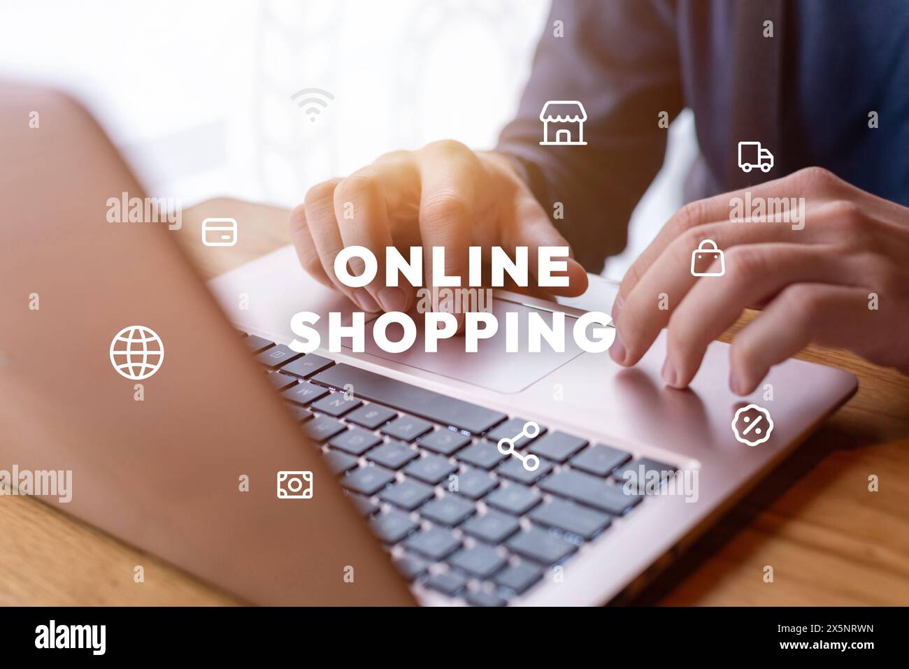Man using laptop for online shopping with levitating icons and text. Modern e-commerce concept for digital consumer convenience Stock Photo