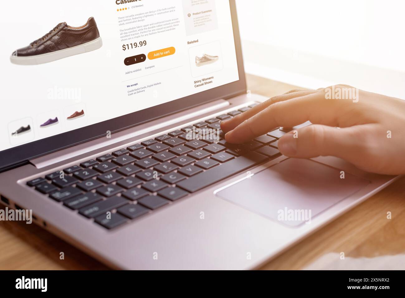 Hands on keyboard searching for modern shoes. E-commerce interface concept. Seamless digital shopping experience for shoe enthusiasts Stock Photo