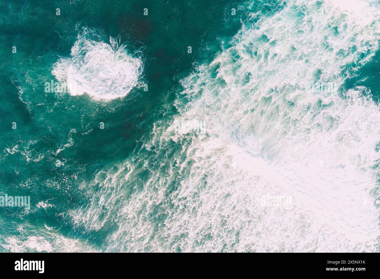 foam from waves on the shore of a beach without people, overhead view with drone Stock Photo