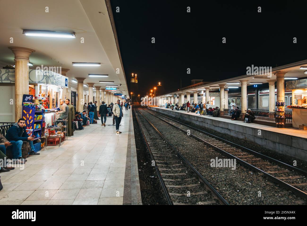 Passengers wait on the platform at Luxor Railway Station, Egypt, at night Stock Photo