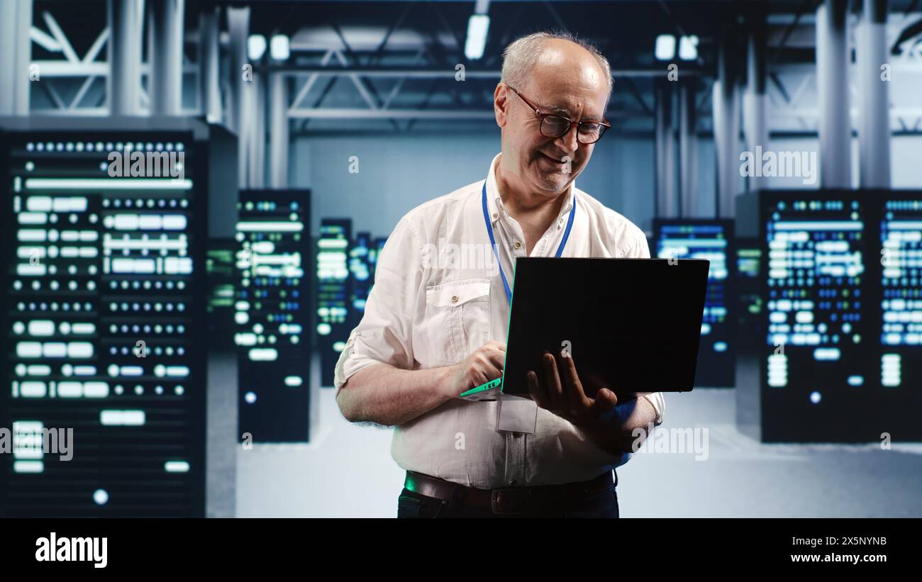 Capable serviceman expertly managing data while navigating in industrial server room. Proficient repairman in high tech facility ensuring optimal cybersecurity protection, optimizing systems Stock Photo