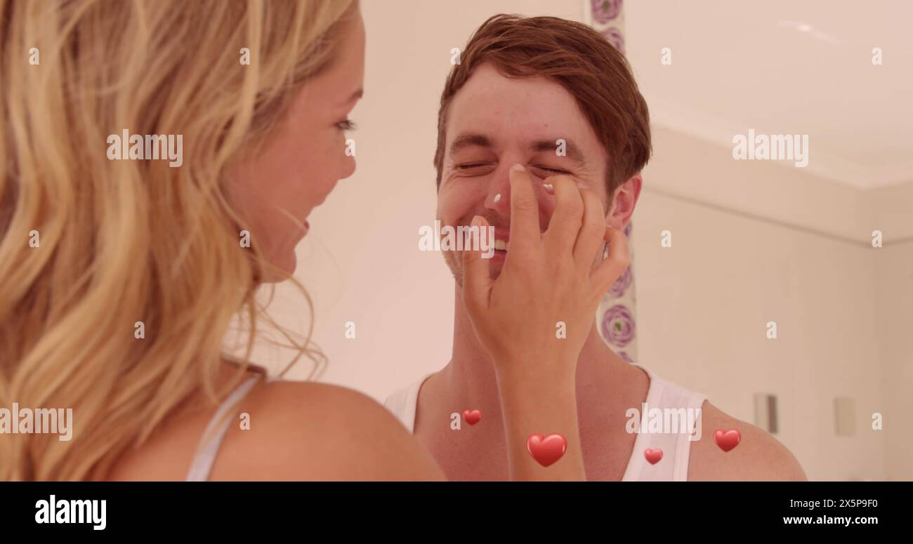 Caucasian couple laughing, woman touching man's face Stock Photo