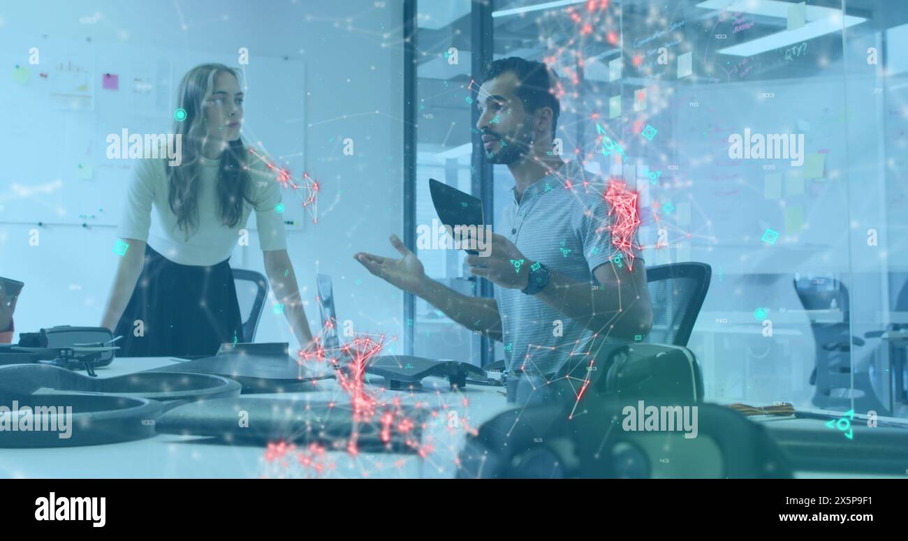 Diverse team discussing over tablet in office Stock Photo