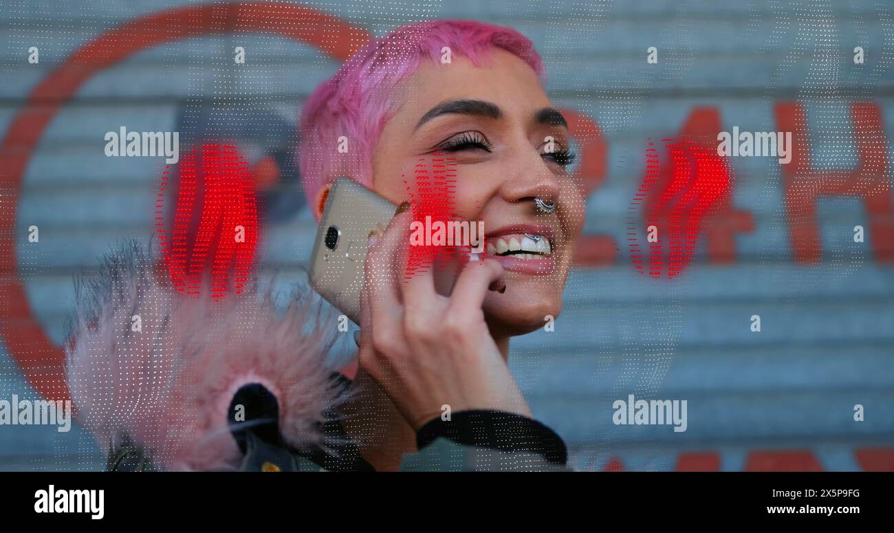 Caucasian female with pink hair is talking on red smartphone Stock Photo