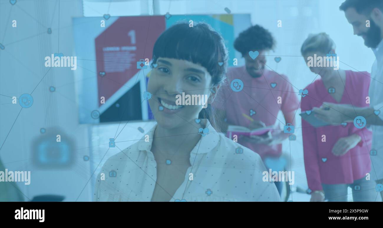 A diverse team is collaborating in office, using digital devices Stock Photo