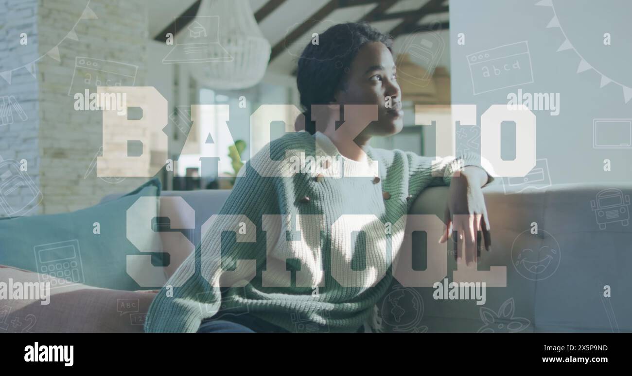 African American woman with short black hair sitting, looking at tablet Stock Photo
