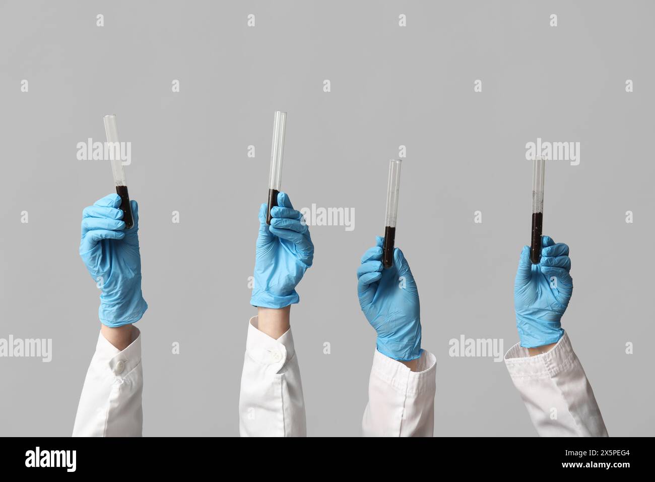 Scientist's hands holding test tubes with soil on white background ...