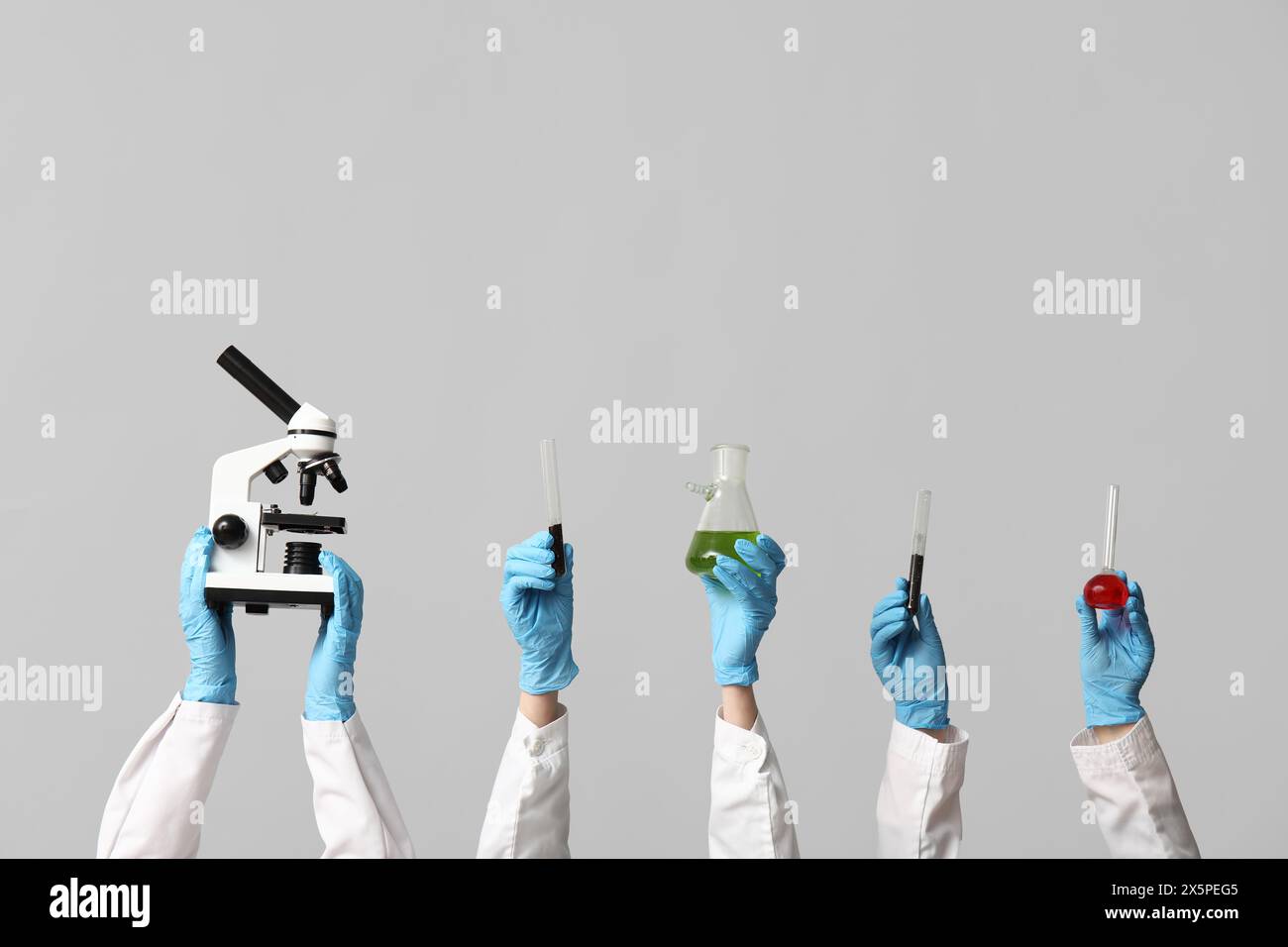 Scientist's hands holding microscope, test tubes with soil, green and ...