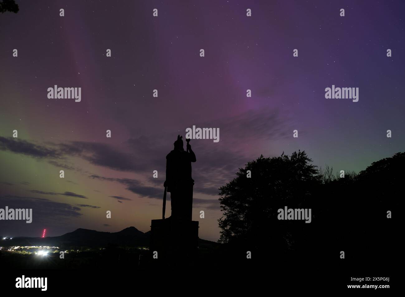 Melrose, UK. 11th May, 2024. The silhouette of the Wallace Statue at Bemersyde looking towards the Eiildons as Northern Lights, Aurora, can be seen in the Scottish Borders. A strong solar storm headed towards Earth has made Northern lights visible in the Scottish Borders. Space weather experts had issued a rare severe geomagnetic storm (G4) warning for this weekend, the first in nearly 20 years. The storm, caused by powerful eruptions known as coronal mass ejections, can trigger spectacular displays of aurora Image Credit: Rob Gray/Alamy Live News Stock Photo
