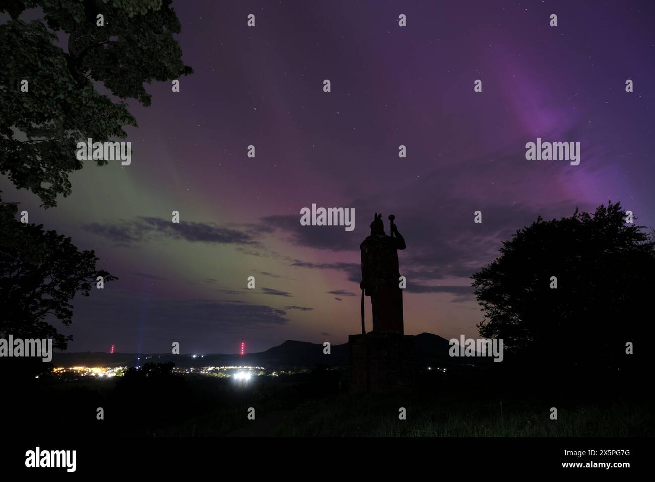 Melrose, UK. 11th May, 2024. The silhouette of the Wallace Statue at Bemersyde looking towards the Eiildons as Northern Lights, Aurora, can be seen in the Scottish Borders. A strong solar storm headed towards Earth has made Northern lights visible in the Scottish Borders. Space weather experts had issued a rare severe geomagnetic storm (G4) warning for this weekend, the first in nearly 20 years. The storm, caused by powerful eruptions known as coronal mass ejections, can trigger spectacular displays of aurora Image Credit: Rob Gray/Alamy Live News Stock Photo