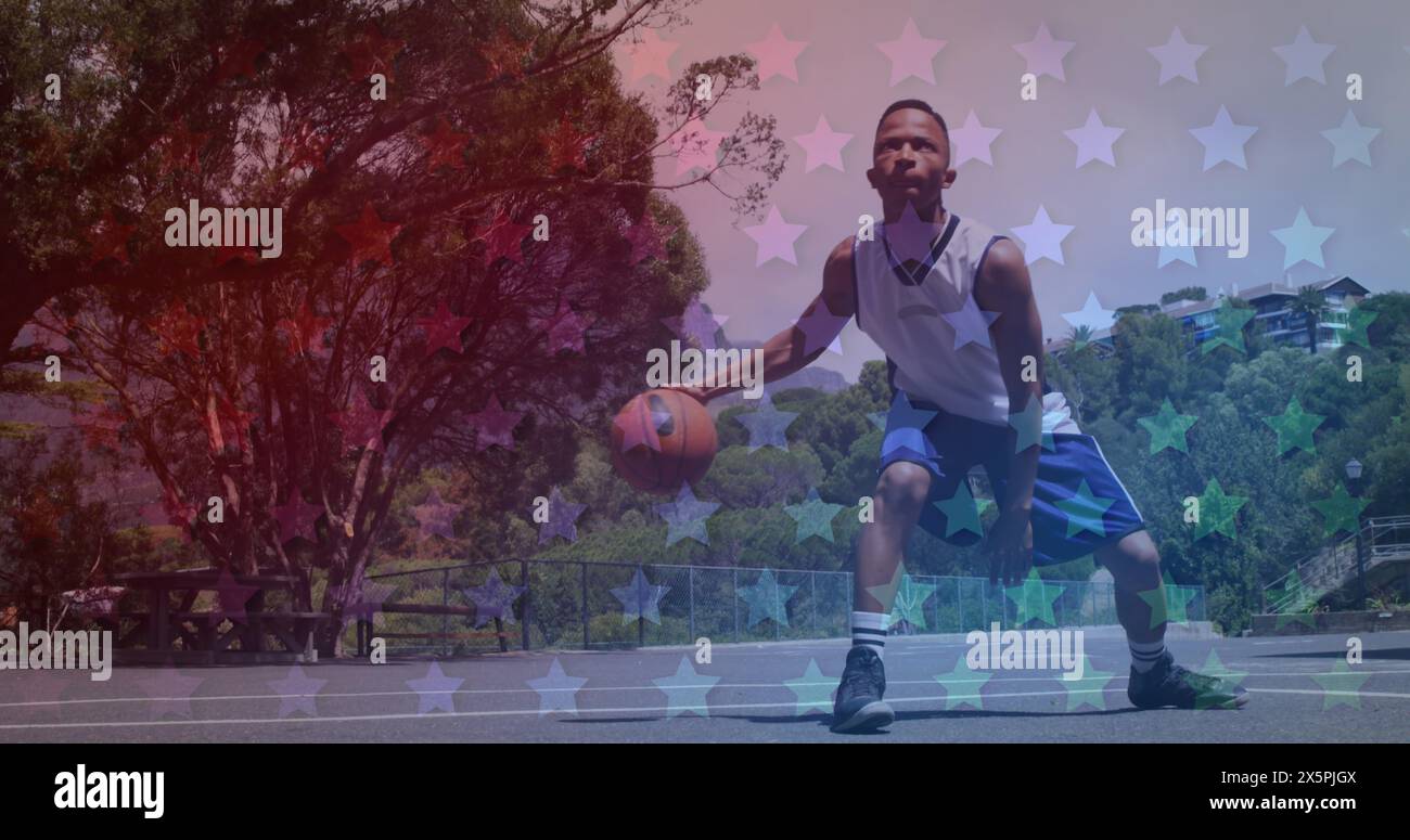 African American fan dribbling basketball on outdoor court Stock Photo